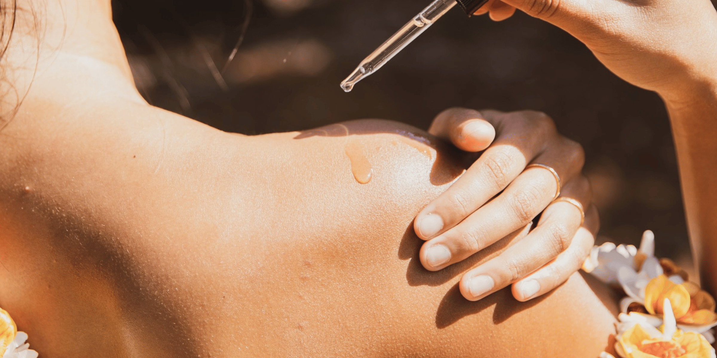 Woman putting oil fragrance onto her shoulder and about to rub it in