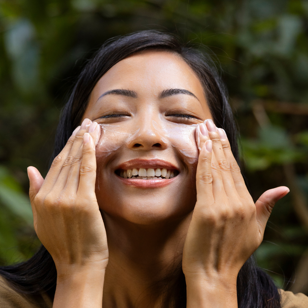 Woman rubbing cleanser into her face while smiling